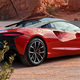 Rear quarter view of 2023 McLaren Artura, in Burnt Orange.